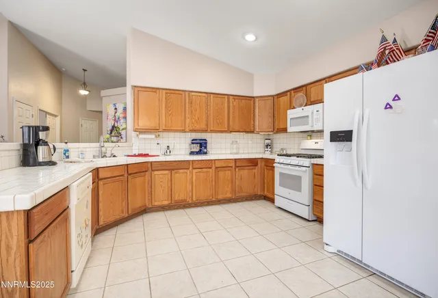 a kitchen with a sink a stove a refrigerator and white cabinets