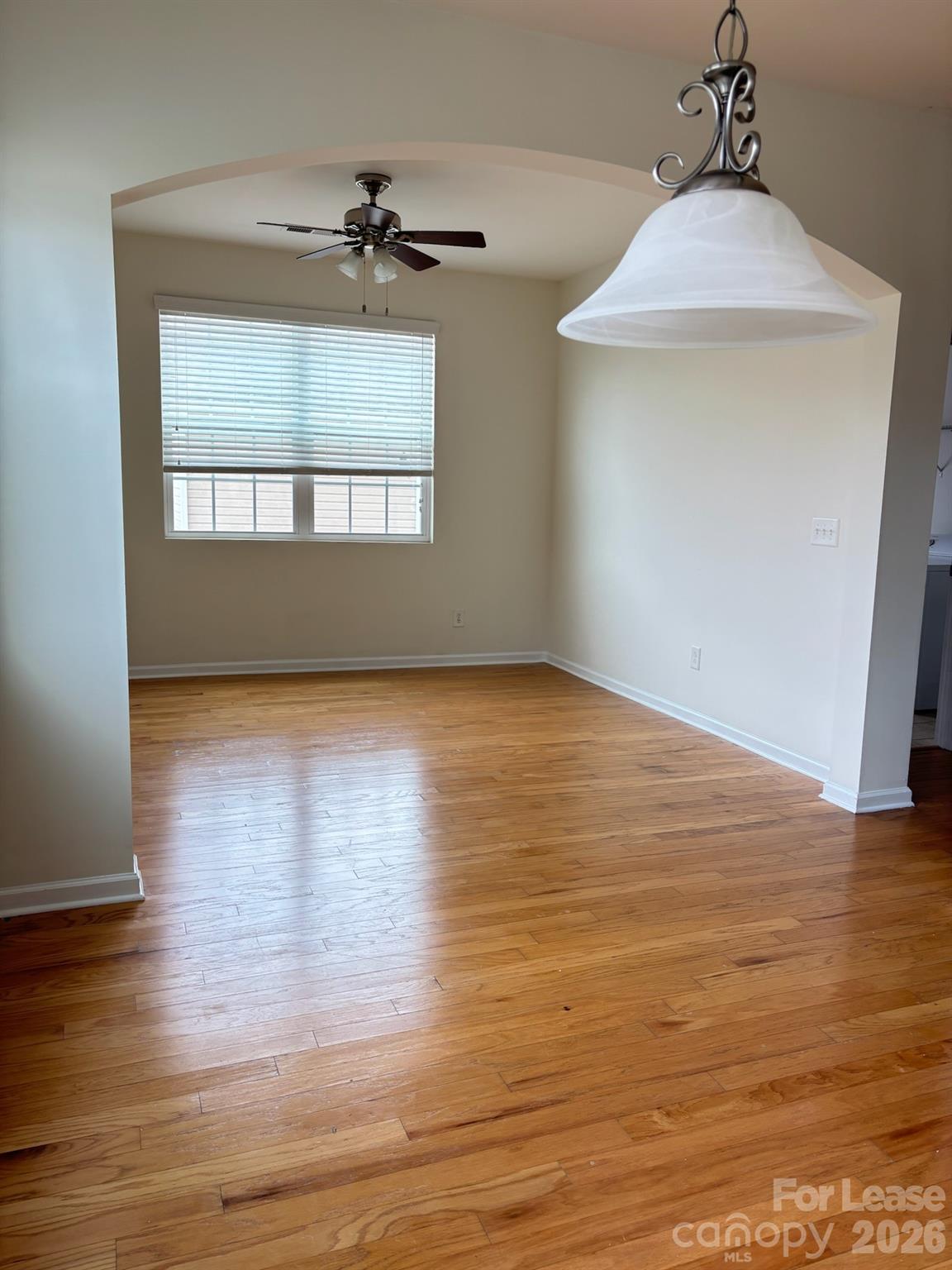 17924 Ragtop Day Lane Cornelius, NC 28031 - Photo 12 of 47 an empty room with wooden floor chandelier and windows