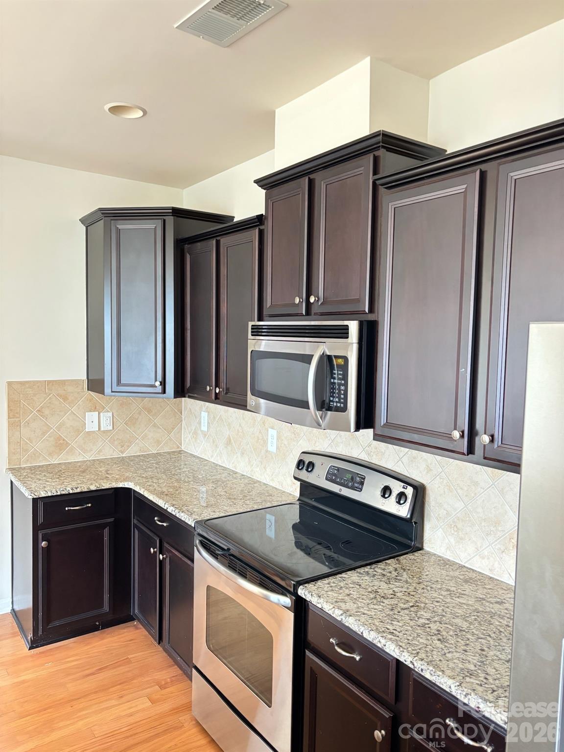17924 Ragtop Day Lane Cornelius, NC 28031 - Photo 18 of 47 a kitchen with granite countertop a stove and a microwave