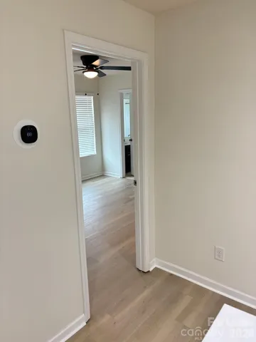 an empty room with window and refrigerator