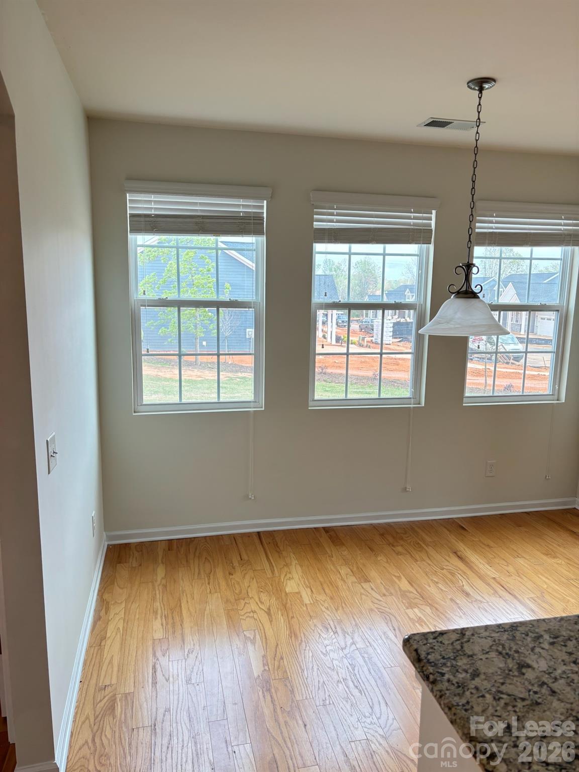 17924 Ragtop Day Lane Cornelius, NC 28031 - Photo 10 of 47 a view of an empty room with wooden floor and a window