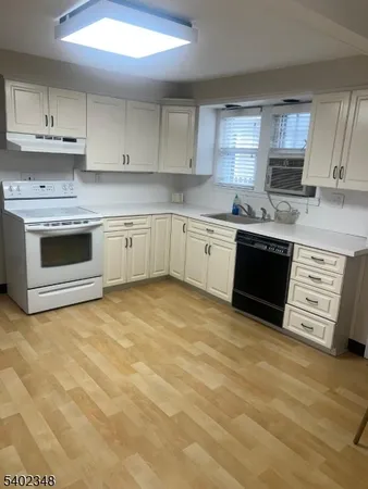 a kitchen with stainless steel appliances granite countertop a stove sink and cabinets
