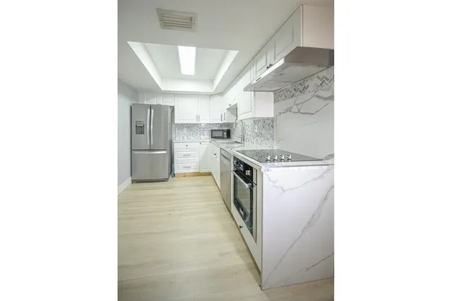 a kitchen with stainless steel appliances granite countertop a sink and a stove