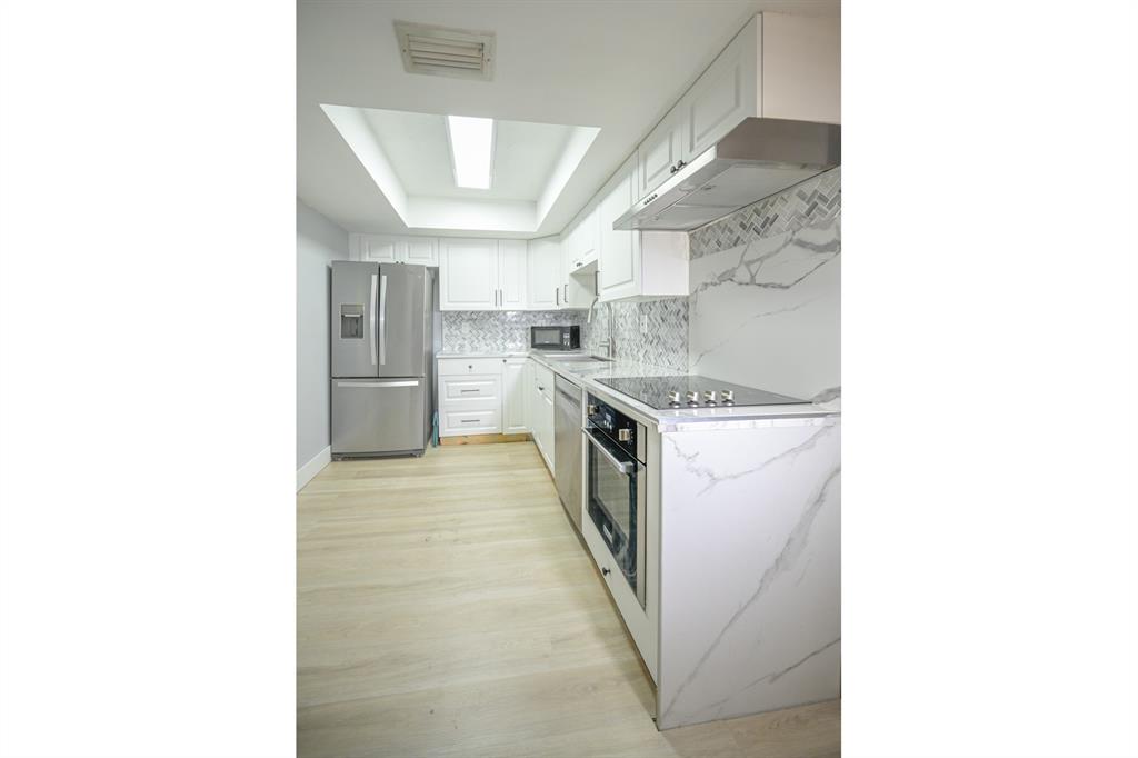 1775 Washington Avenue, Unit 5A Miami Beach, FL 33139 - Photo 13 of 21 a kitchen with stainless steel appliances granite countertop a sink and a stove
