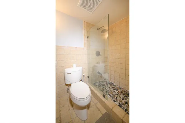 a bathroom with a toilet and a shower