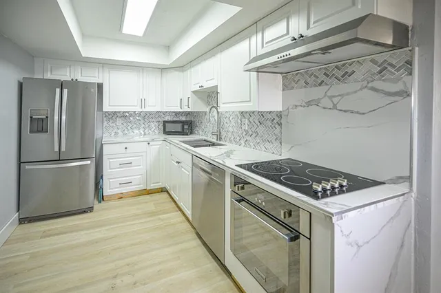 a kitchen with stainless steel appliances a stove a sink and a refrigerator