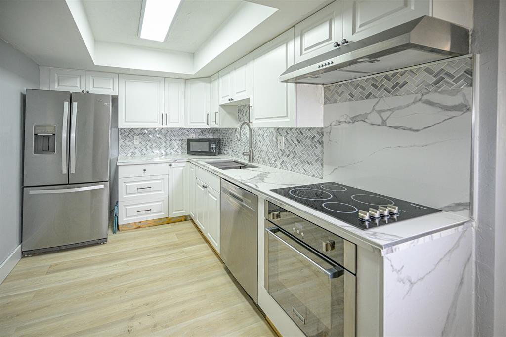 1775 Washington Avenue, Unit 5A Miami Beach, FL 33139 - Photo 2 of 21 a kitchen with stainless steel appliances a stove a sink and a refrigerator