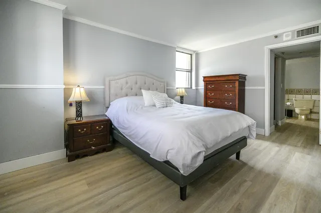 a bedroom with a bed and wooden floor