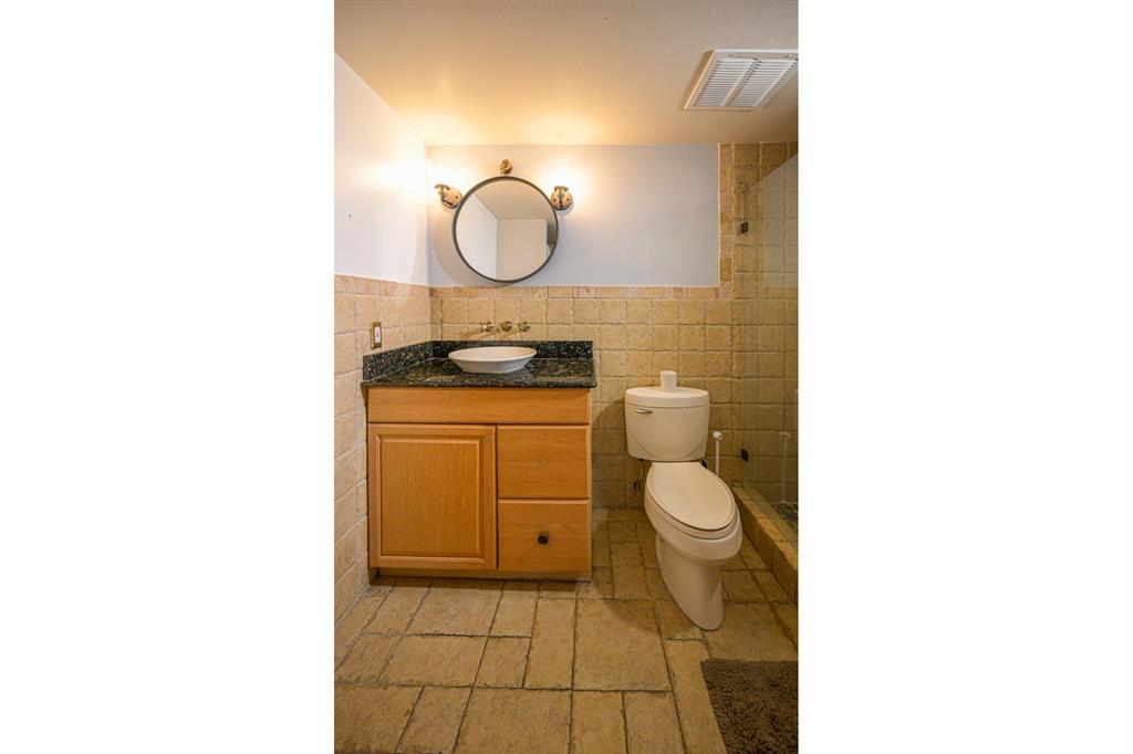 1775 Washington Avenue, Unit 5A Miami Beach, FL 33139 - Photo 5 of 21 a bathroom with a granite countertop toilet sink and mirror