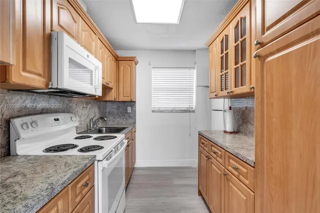 a kitchen with stainless steel appliances granite countertop a sink a stove and a microwave