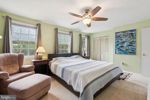 a bedroom with a large bed and windows