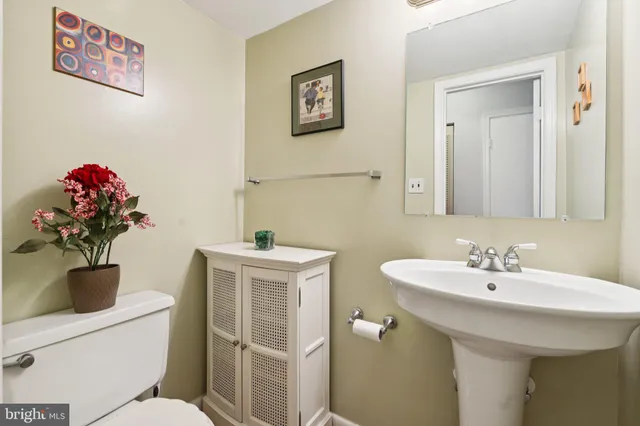 a bathroom with a sink a toilet and a mirror