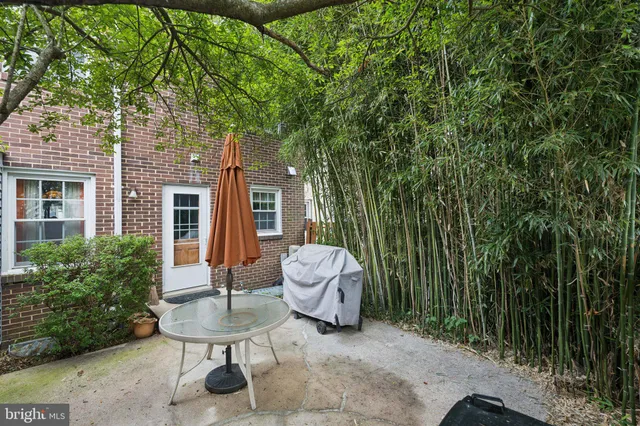 a view of a backyard with table and chairs and a barbeque