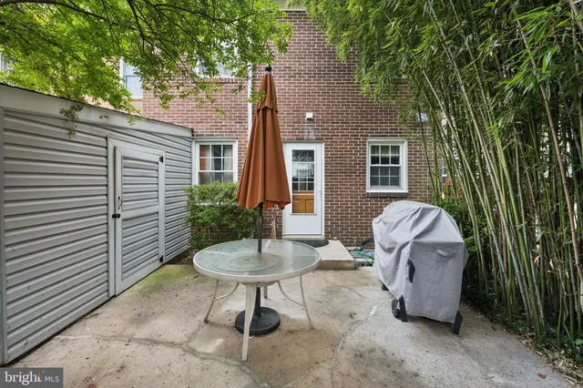a view of a backyard with plants and white fence