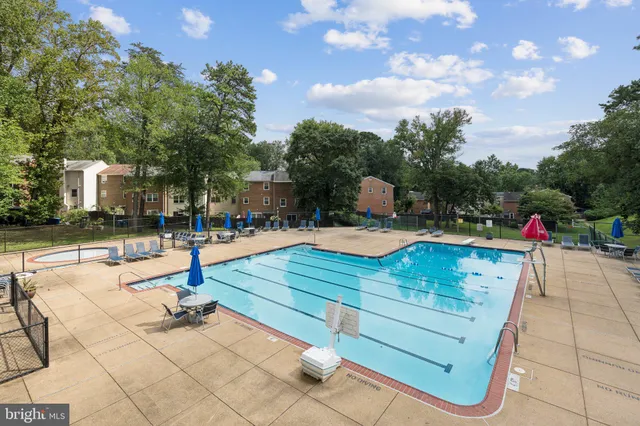a front view of a house with a garden and trees