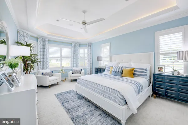 a bedroom with a bed couch and windows