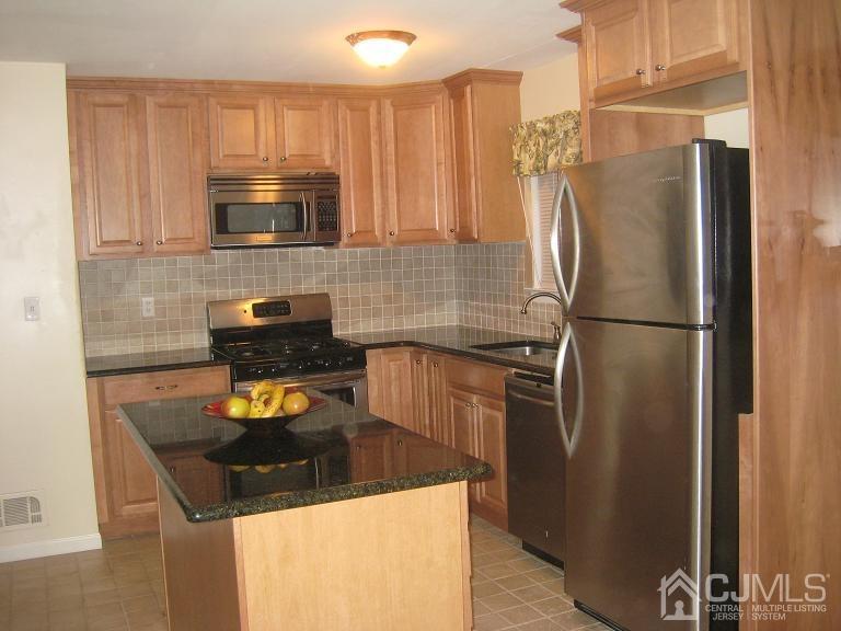 22 King Road Somerset, NJ 08873 - Photo 4 of 19 a kitchen with stainless steel appliances granite countertop a refrigerator a stove and a sink with wooden floor