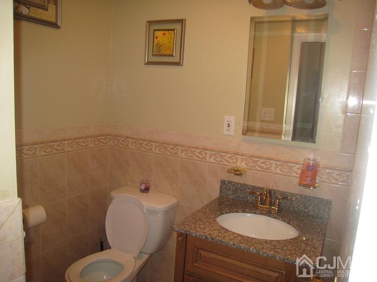 22 King Road Somerset, NJ 08873 - Photo 8 of 19 a bathroom with a granite countertop toilet a sink and mirror