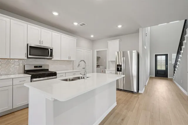 a kitchen with stainless steel appliances a refrigerator stove microwave and cabinets