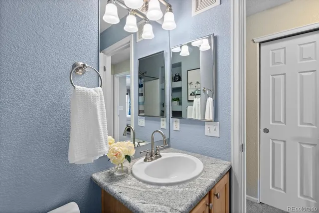 a bathroom with a granite countertop sink a mirror and shower