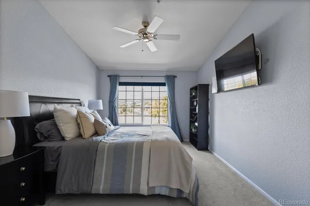 a bedroom with a bed and a flat tv screen on dresser