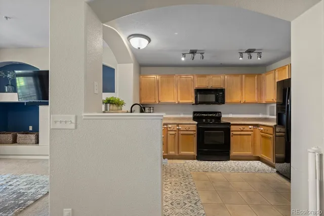 a kitchen with stainless steel appliances granite countertop a refrigerator sink and stove