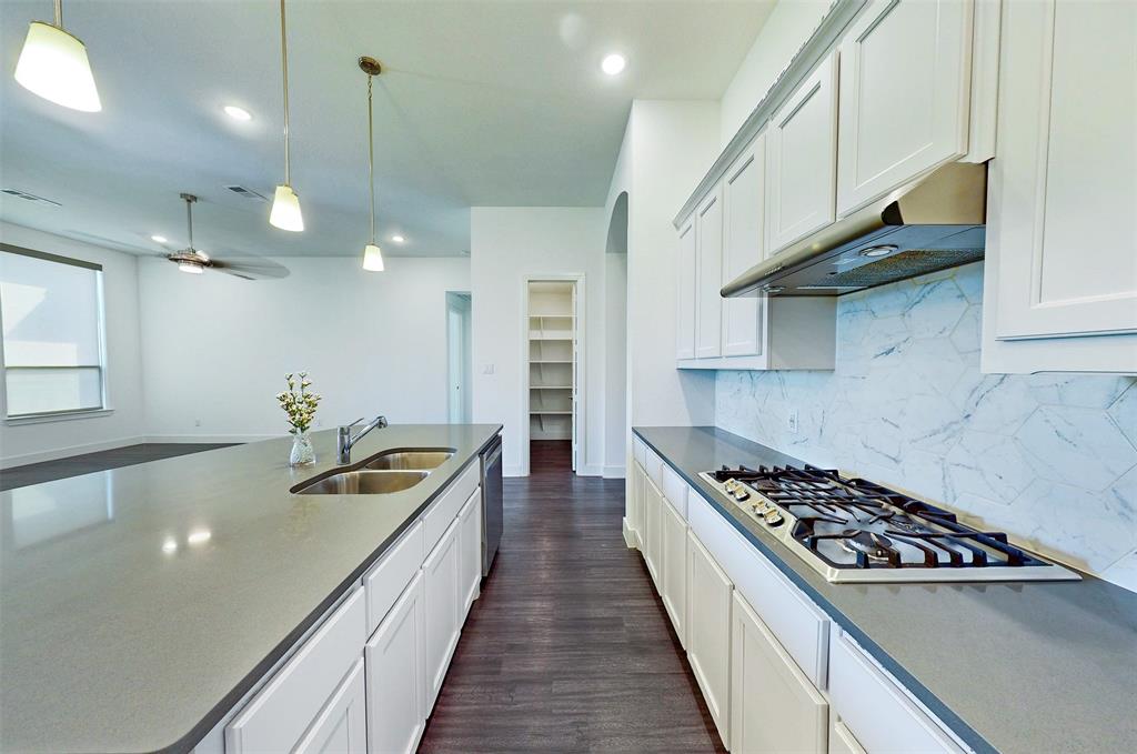 2032 Longbridge Road Forney, TX 75126 - Photo 11 of 40 a kitchen with kitchen island stainless steel appliances a sink a counter top space stove and cabinets