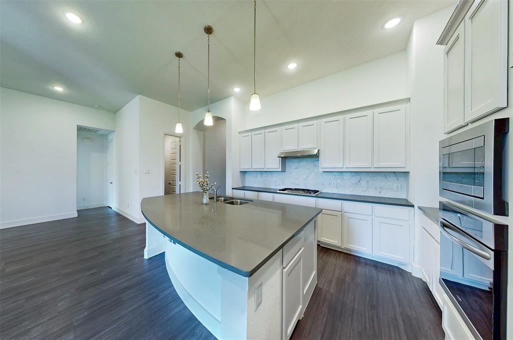 2032 Longbridge Road Forney, TX 75126 - Photo 13 of 40 a kitchen with stainless steel appliances granite countertop a sink a stove and a wooden floors