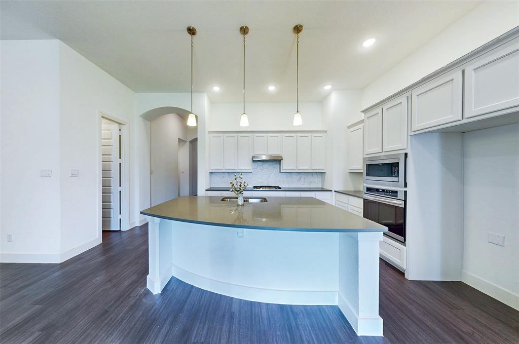 2032 Longbridge Road Forney, TX 75126 - Photo 14 of 40 a view of a kitchen with kitchen island a sink stainless steel appliances and cabinets