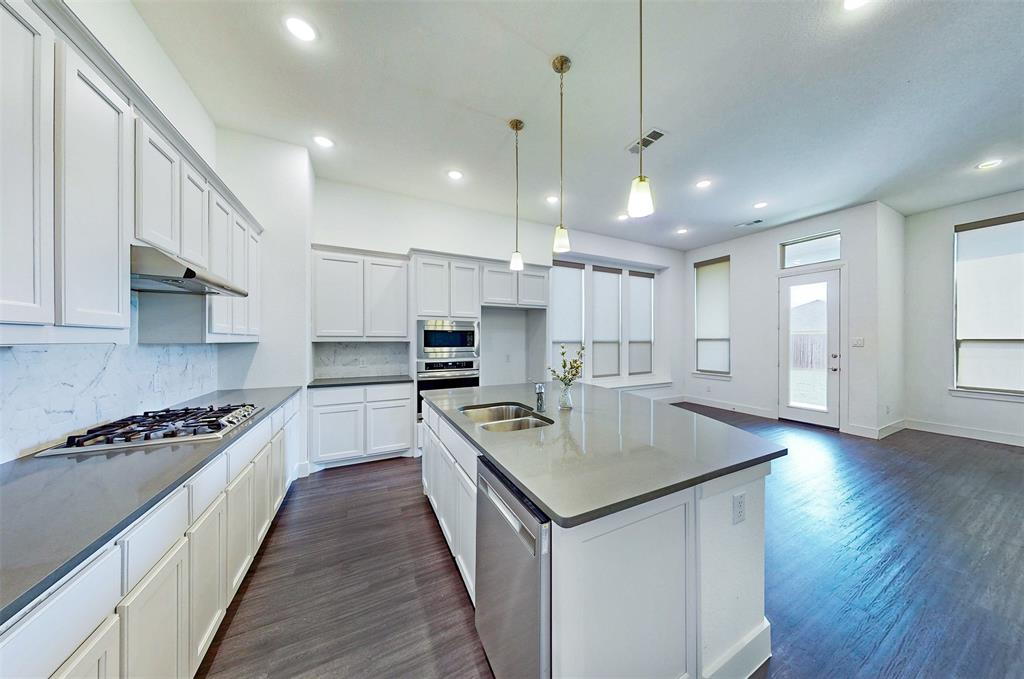 2032 Longbridge Road Forney, TX 75126 - Photo 9 of 40 a kitchen with kitchen island a sink stove and wooden floor