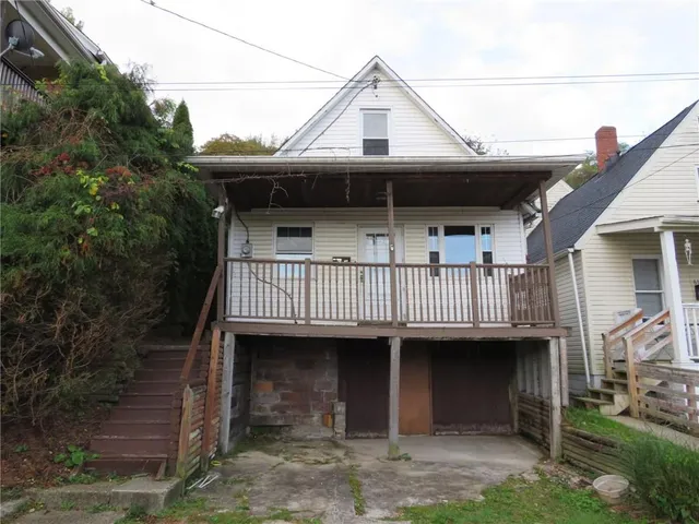 a view of a house with a deck and a yard