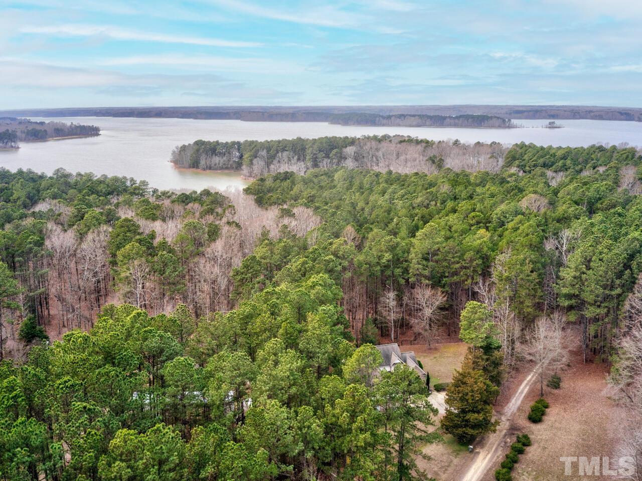 361 Sandy Point Drive Manson, NC 27553 - Photo 42 of 49 a view of a yard with an ocean and trees in the background