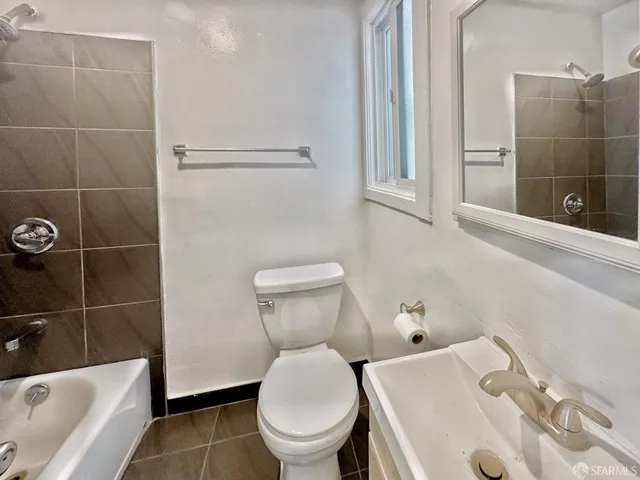 a white toilet sitting next to a bathroom sink and tub