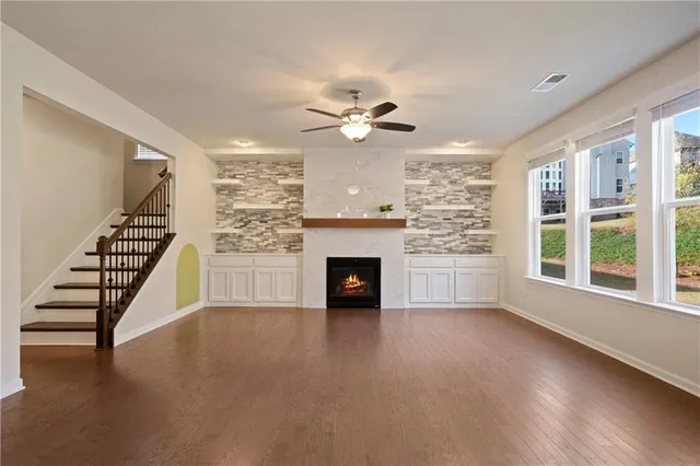 wooden floor fireplace and windows in an empty room