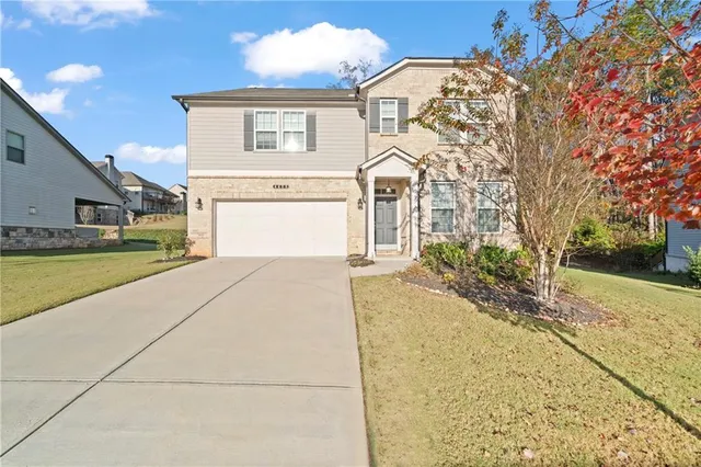 a front view of a house with a yard and garage