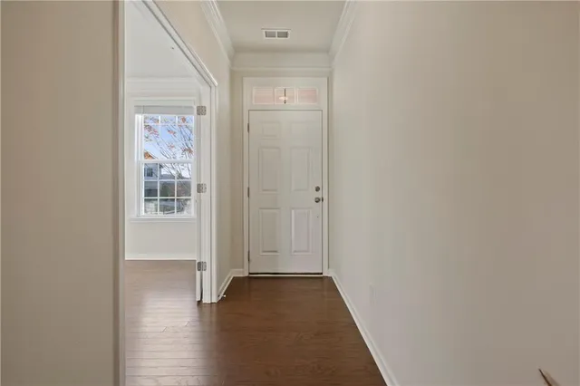 a view of a hallway with wooden floor and closet