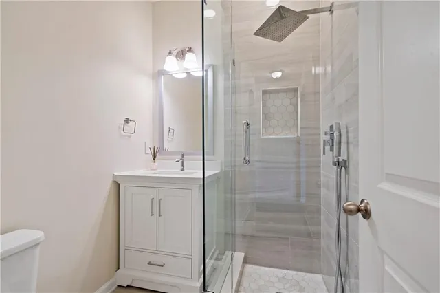 a bathroom with a shower a sink and mirror