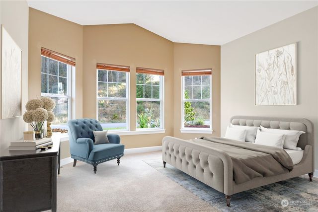 a bedroom with a bed and a couch next to a window