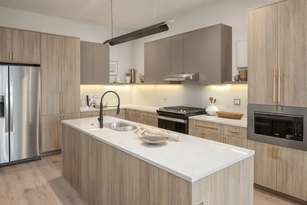 a kitchen with stainless steel appliances a sink a stove a refrigerator and cabinets