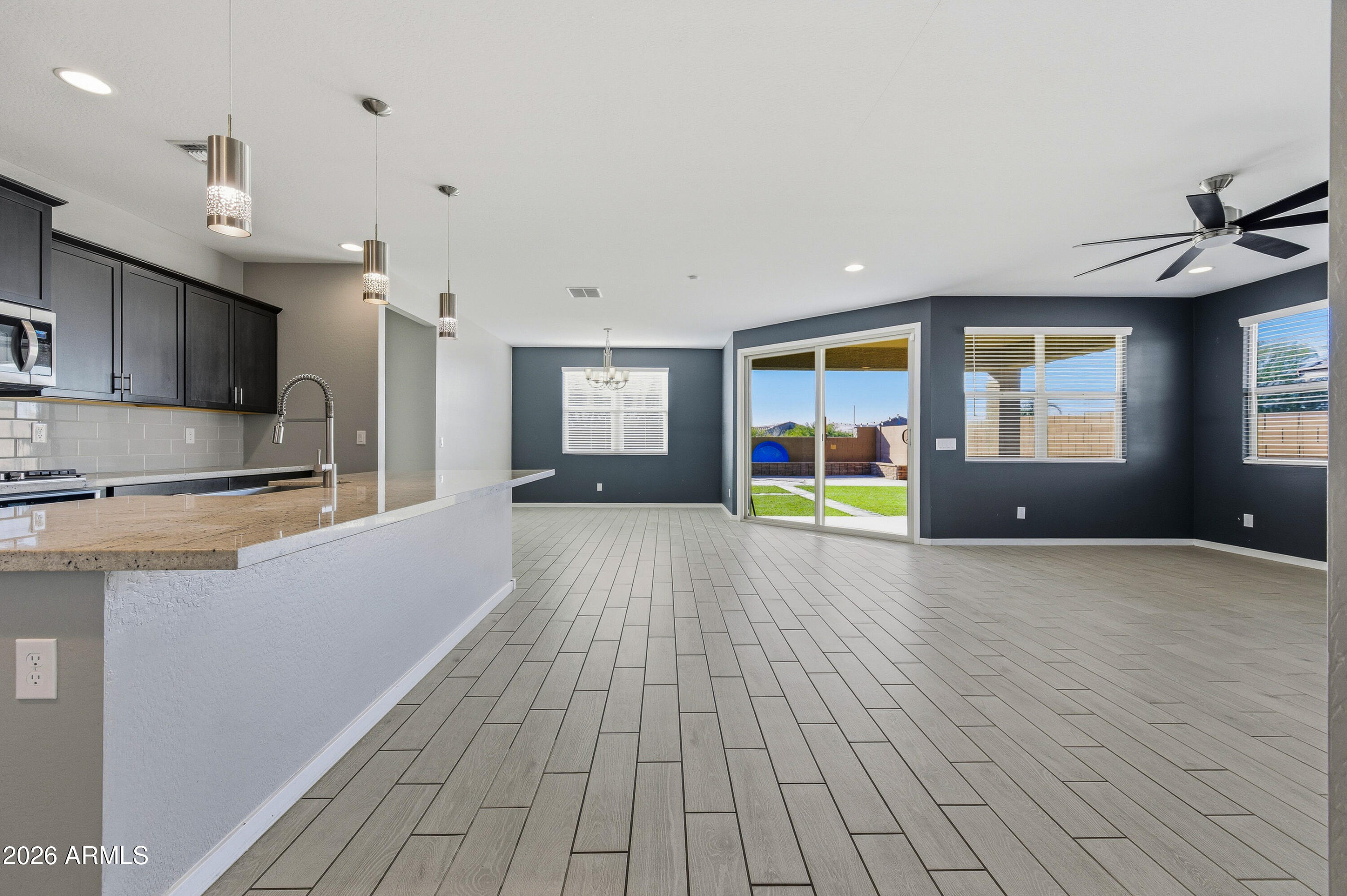 18225 West Pierson Street Goodyear, AZ 85395 - Photo 11 of 39 a view of open kitchen with wooden floor and electronic appliances