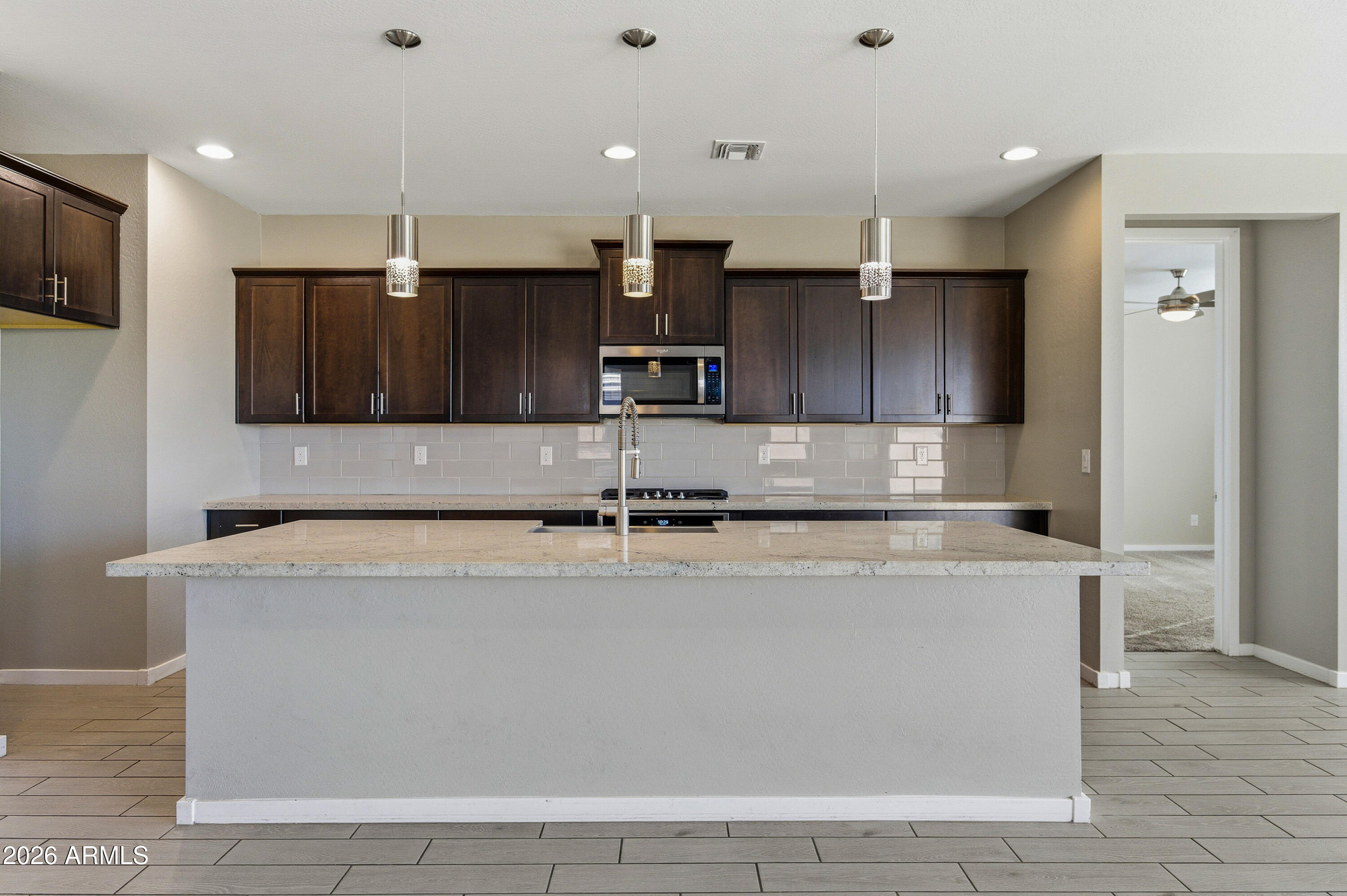 18225 West Pierson Street Goodyear, AZ 85395 - Photo 19 of 39 a large kitchen with stainless steel appliances granite countertop a sink a stove and a refrigerator