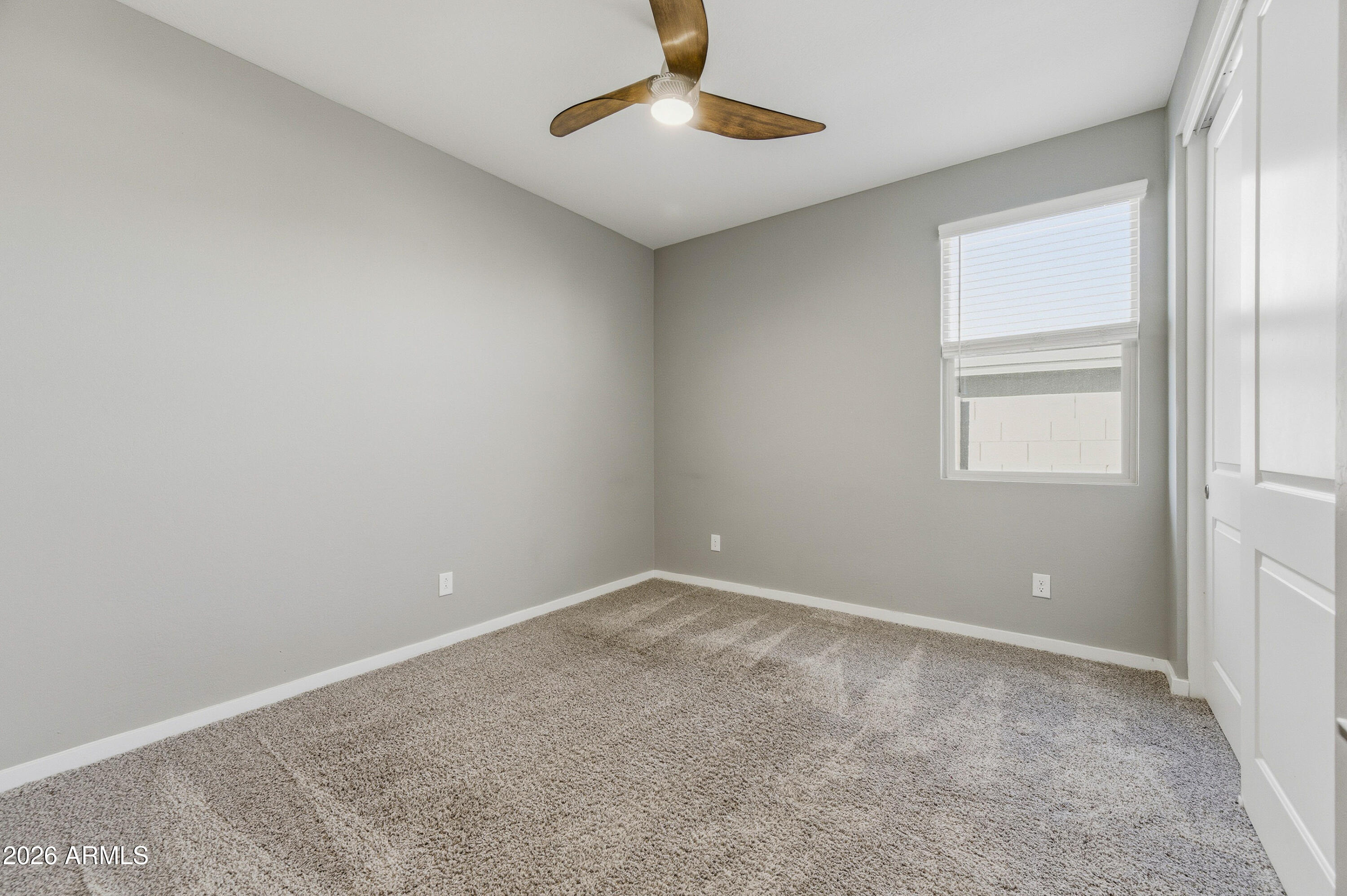 18225 West Pierson Street Goodyear, AZ 85395 - Photo 9 of 39 an empty room with a window and chandelier fan