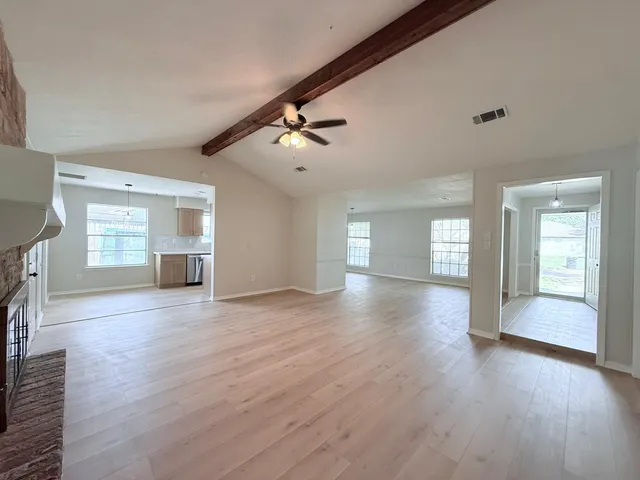 a view of an empty room with a window and fireplace