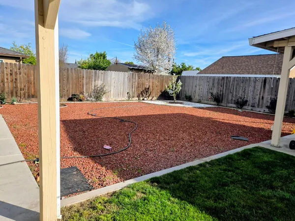 a view of a backyard with wooden fence