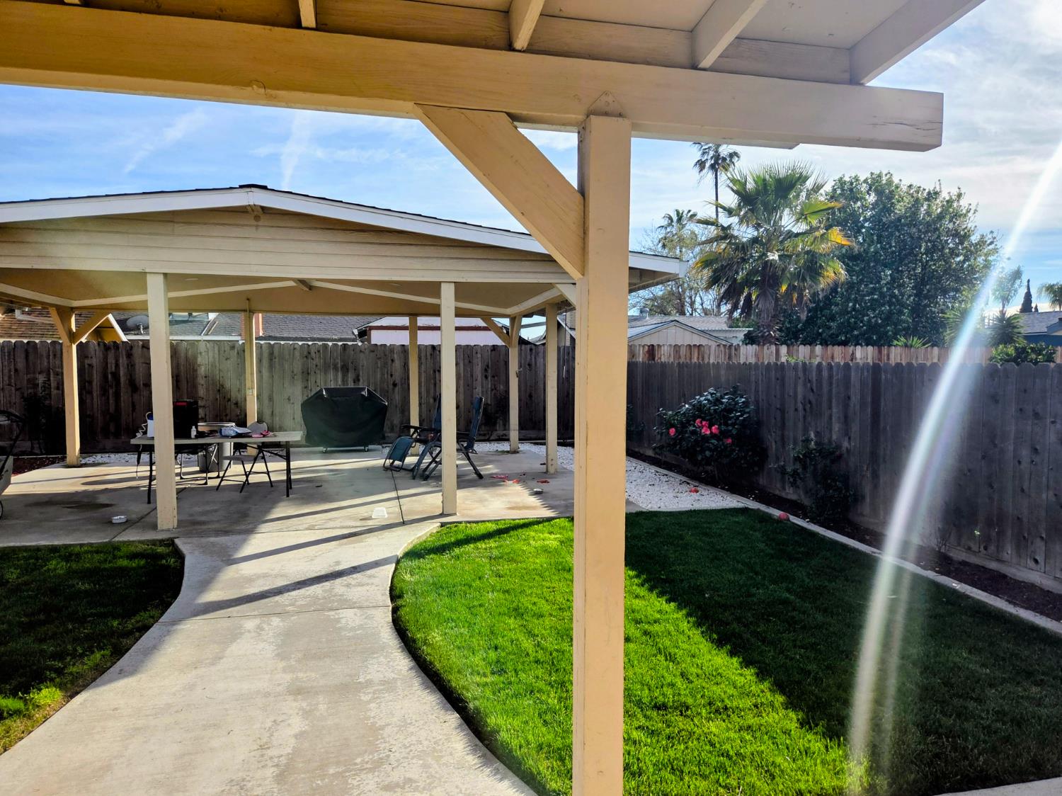 1404 Solar Avenue Modesto, CA 95351 - Photo 25 of 28 a view of a patio with table and chairs potted plants and floor to ceiling window and wooden fence