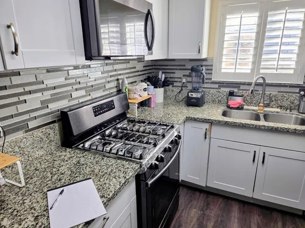 a kitchen with a stove a sink and a microwave