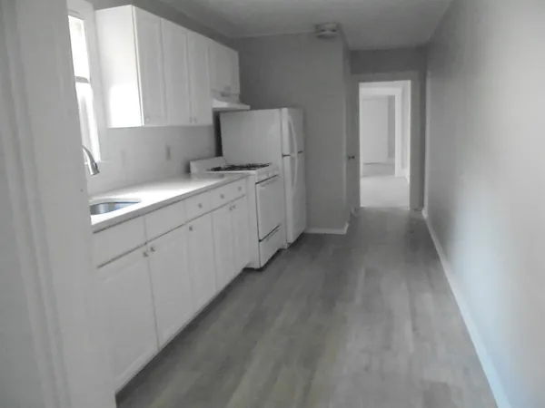 a kitchen with white cabinets and white appliances
