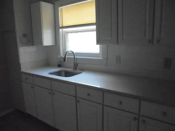 a kitchen with a sink cabinets and window