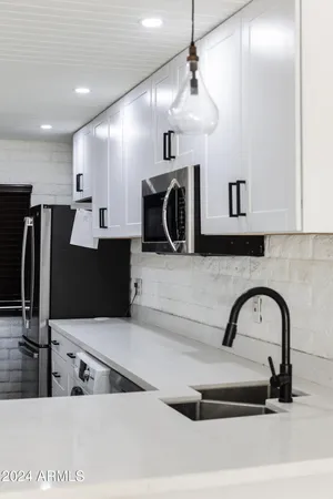 a kitchen with kitchen island a counter top a stove and a refrigerator