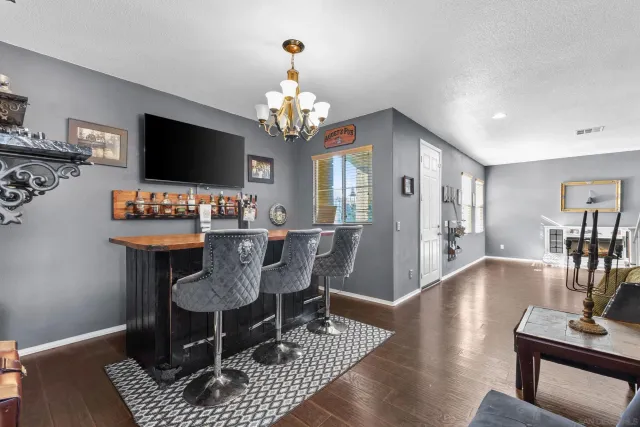 a view of a dining room with furniture a rug and wooden floor
